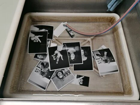 entwickelte Fotos in einer Wasserwanne eines Fotolabors